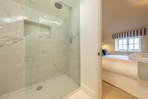 a bathroom with a shower with a glass door at The Coach House R 6 in Ringstead +32 photos