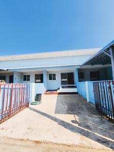 un edificio blanco con una valla delante en Baan Meen - Vacation Home, en Ban Huai Phlu
