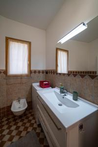 uma casa de banho com um lavatório, um espelho e um WC. em CASA SMERALDO - LIGHT BLUE em Clusane sul Lago