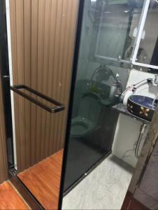 a glass shower door with a sink in a bathroom at Sleep Cubee Hostel in Hong Kong