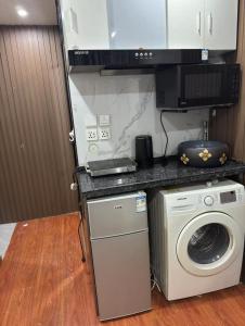 a kitchen with a washer and a washing machine at Sleep Cubee Hostel in Hong Kong
