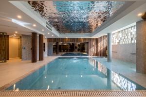 a swimming pool in a building with a ceiling at Hotel Fanat in Split