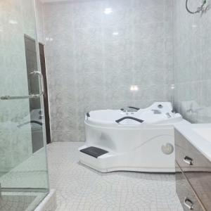 a white bathroom with a sink and a shower at The Residenze Adeniyi Jone Ikeja in Lagos