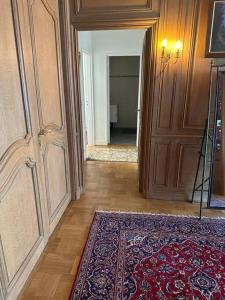 a hallway with a rug and a room with a door at Avenue Foch in Paris