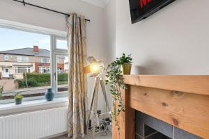 a lamp next to a fireplace in a room with a window at Whitehill House - 3-Bed Home from Home, Sleeps 7, Great for Groups & Workers, FREE Parking & Netflix in Whiston