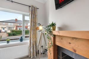 eine Lampe in einem Zimmer mit einem Kamin und einem Fenster in der Unterkunft Whitehill House - 3-Bed Home from Home, Sleeps 7, Great for Groups & Workers, FREE Parking & Netflix in Whiston