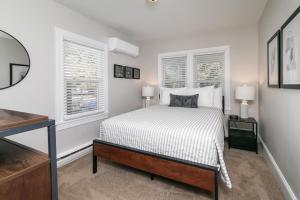 a white bedroom with a bed and two windows at Salisbury Hideaway in Salisbury