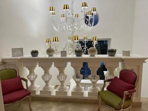 a living room with two chairs and a table with vases at Relais Corte Degli Aragonesi in Ischia
