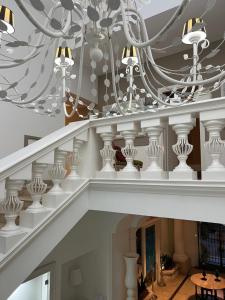 a white staircase with a chandelier at Relais Corte Degli Aragonesi in Ischia