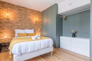 um quarto com uma cama e uma parede de tijolos em Charming 2 bedroom apartment - Old Lille em Lille