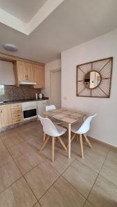 a kitchen with a wooden table and white chairs at Sunny Suite in San Miguel de Abona +52 photos