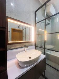 y baño con lavabo blanco y ducha. en Villa Kamar Tamu Sidokarto en Godean