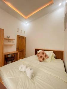 Un dormitorio con una cama blanca con toallas. en Villa Kamar Tamu Sidokarto en Godean