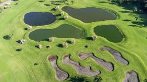 an aerial view of a golf course with three ponds at Batalha Golf Villa in Pico da Pedra