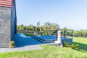 a house with a blue staircase leading to a yard at Batalha Golf Villa in Pico da Pedra