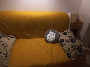 Una cama amarilla con un animal de peluche. en Le patio, en Oloron-Sainte-Marie