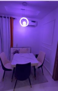 a dining room with a table and chairs and a light at Sambest Homes in Lagos