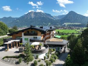 an aerial view of a house with a mountain in the background at Naturhotel Café Waldesruhe in Oberstdorf