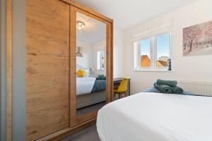 a bedroom with a large wooden closet and a bed at Luxury house close to city center sleeps 6 with free parking in Leicester