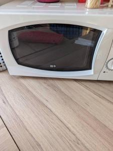a white microwave oven sitting on a wooden floor at Le Chalet du Viaur in Tanus