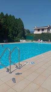 ein Pool mit blauem Wasser und einigen Stühlen in der Unterkunft Appartamento Monvalle Home in  Monvalle 