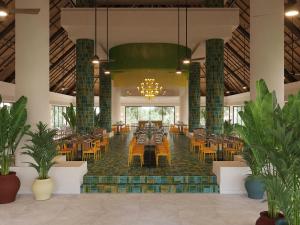 艾庫瑪爾的住宿－Bahia Principe Luxury Akumal - All Inclusive，大楼内带桌椅的餐厅