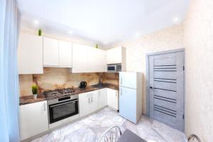 a kitchen with white cabinets and a white refrigerator at Европейская Пассаж ЦУМ in Dnipro