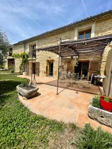 un patio di fronte a una casa in pietra di La Maison Bliss a Piolenc