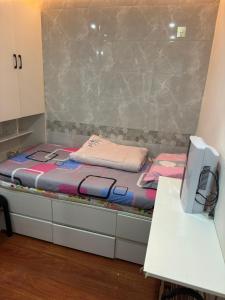 a bed in a room with a desk and a computer at Sleep Cubee Hostel in Hong Kong