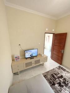 ein Wohnzimmer mit einem Flachbild-TV auf einem Schrank in der Unterkunft Homestay Kamar Tamu Sitimulyo in Karanggayam
