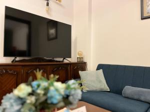 sala de estar con sofá azul y TV de pantalla plana en City centre stylish apartament with private backyard en Sofía