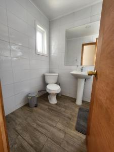 łazienka z toaletą i umywalką w obiekcie Casa familiar w mieście Cochrane
