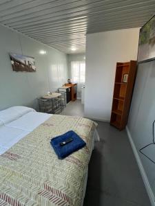 a bedroom with a bed with a blue towel on it at Mini Departamento C8 in Calama