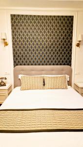 a bedroom with a large bed with a large headboard at Hotel Dandy Rouen centre in Rouen