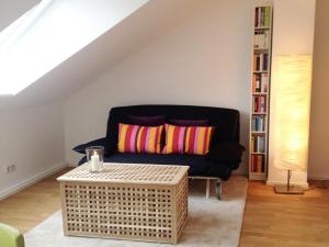 ein Wohnzimmer mit einem schwarzen Sofa und einem Tisch in der Unterkunft Ferienwohnung Dörrie im Zentrum in Münster