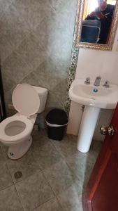 een badkamer met een toilet en een wastafel bij HOTELERIA CASA MAYA in Riobamba