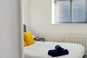 a bedroom with a bed with blue towels on it at Modern Apartment with Pool table in Leicester