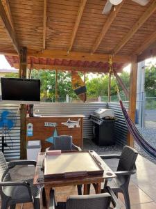 カボ・ロホにあるVilla Retiro R in Boquerón Areaのテーブルと椅子とグリルのあるパティオ