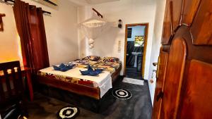 a bedroom with a bed and a door to a room at Hakuna Matata Arugambay in Arugam Bay