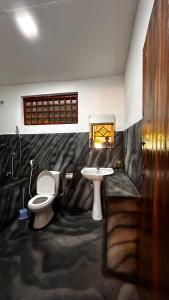 een badkamer met een toilet en een wastafel bij Hakuna Matata Arugambay in Arugam Bay