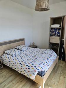 Schlafzimmer mit einem Bett mit einer blauen und weißen Bettdecke in der Unterkunft Gite canard in Fromelles