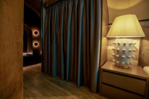 a lamp on a dresser next to a curtain at CadensPlace - Overlooking Piazza Navona by dbalconycollection in Rome