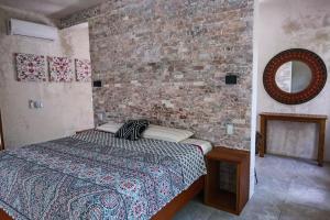 1 dormitorio con cama y pared de ladrillo en Beunavista Villas, en Buenavista