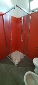 La salle de bains rouge est pourvue d'une douche et de toilettes. dans l'établissement Villaggio Jonio Blu, à Bianco