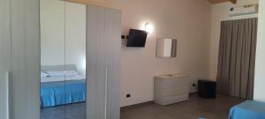- une chambre avec un lit et un miroir dans l'établissement Villaggio Jonio Blu, à Bianco