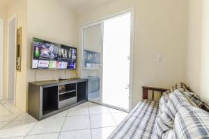 ein Wohnzimmer mit einem TV und einem Sofa in der Unterkunft Apartamento 2 dormitorios Novo Hamburgo Espaço Namibe in Novo Hamburgo