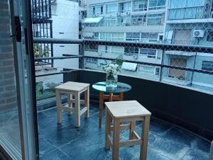 d'une table et de deux tabourets sur un balcon. dans l'établissement Departamento Ciudad de la Paz, à Buenos Aires