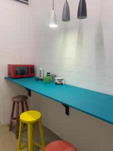 a kitchen with a blue counter and two stools at Hostal YOA Suite 101 in Mexico City