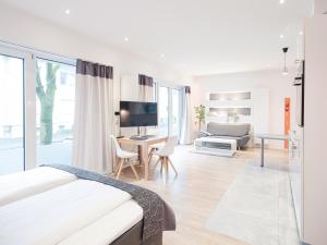 a white bedroom with a bed and a living room at business boarding lippstadt in Lippstadt
