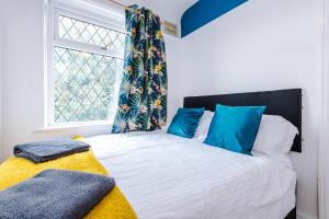 a bedroom with a bed with blue pillows and a window at Cosy 2 Bedroom house-Short drive from Blackpool Pleasure Beach in Blackpool